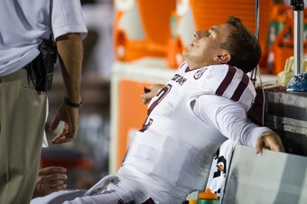 OXFORD, MS - OCTOBER 12:  Quarterback Johnny Manziel #2 of the Texas A&M Aggies is tended to on the bench after being injured during a game against the Ole Miss Rebels on October 12, 2013 at Vaught-Hemingway Stadium in Oxford, Mississippi. At halftime Tex