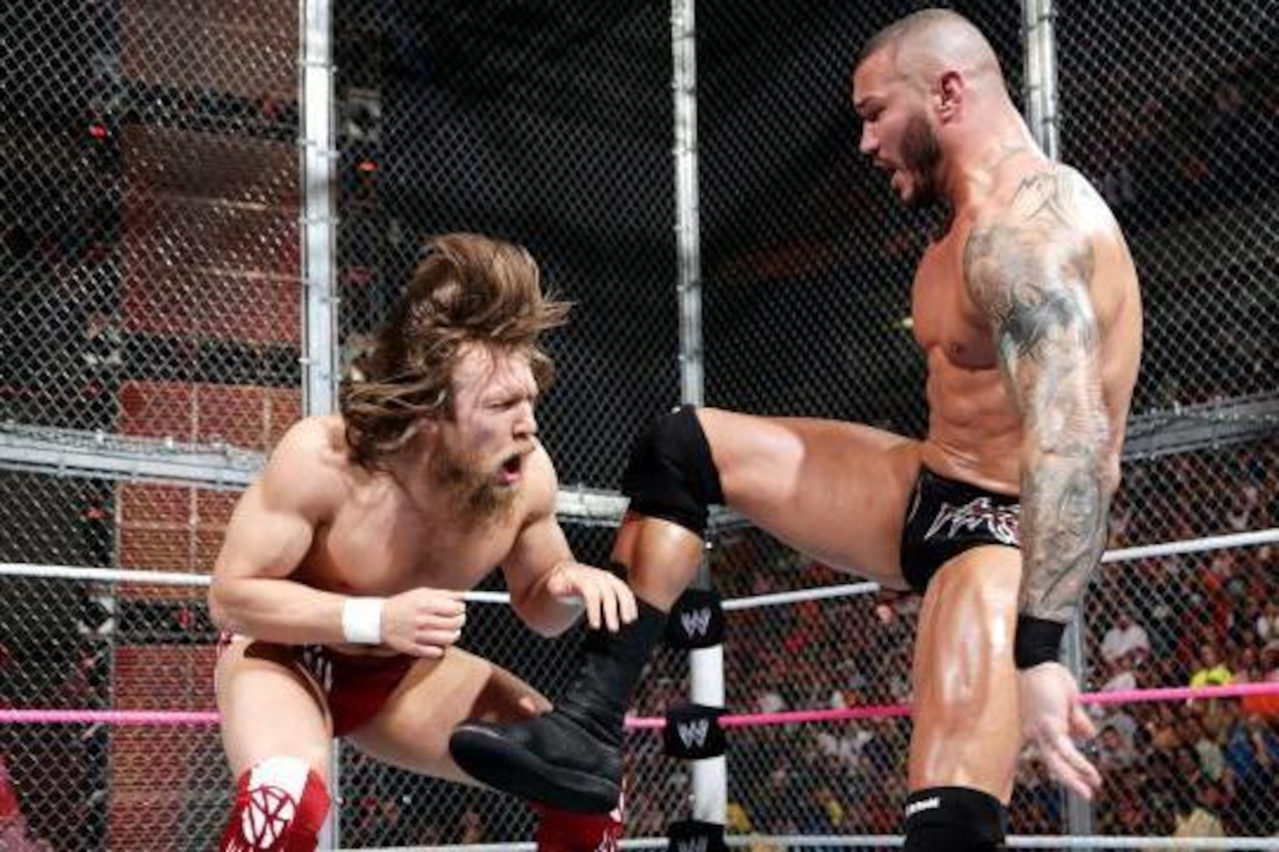 Randy Orton delivers a hard kick to the gut of Daniel Bryan. Randy Orton delivers a hard kick to the gut of Daniel Bryan.