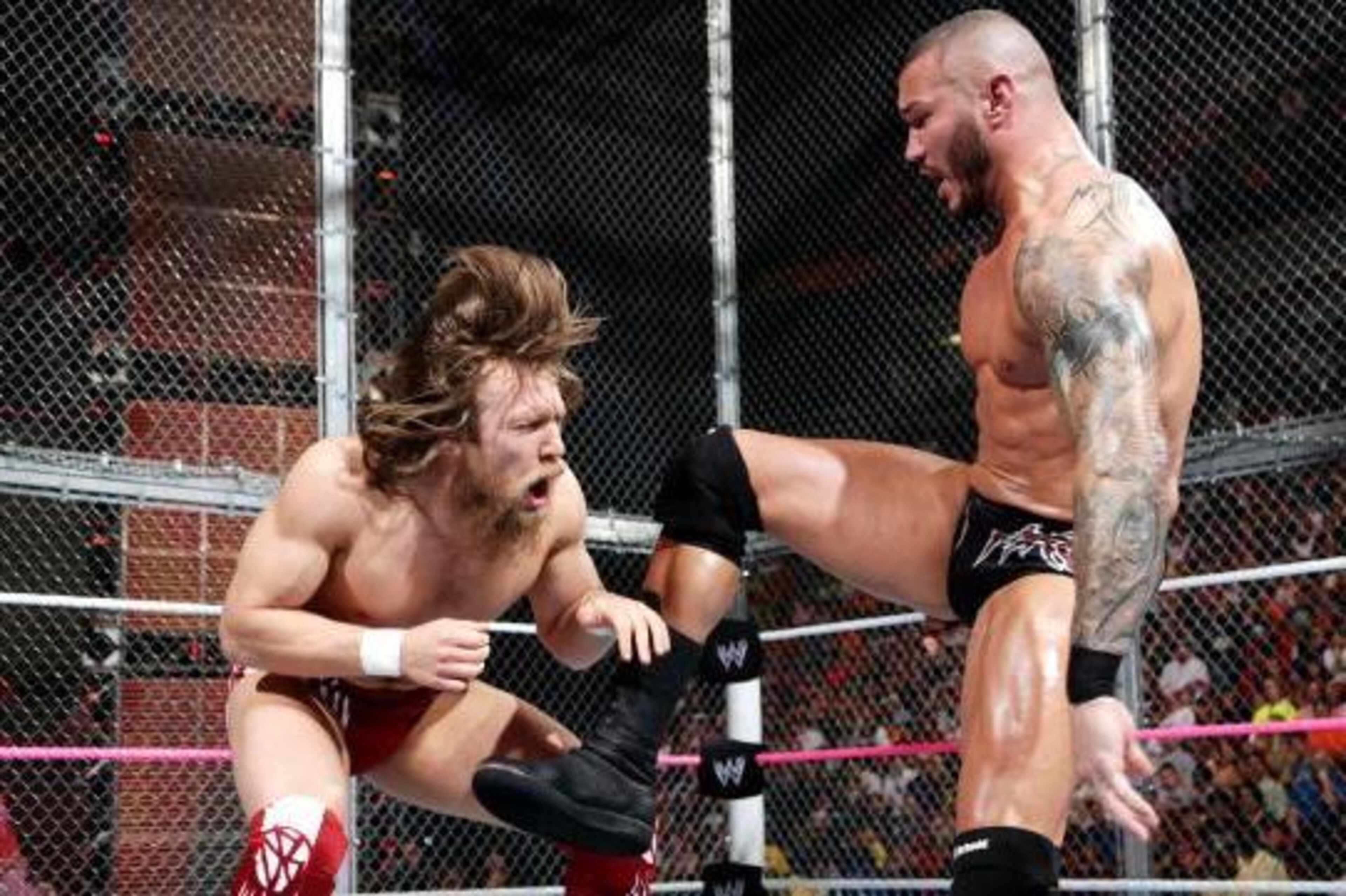 Randy Orton delivers a hard kick to the gut of Daniel Bryan. Randy Orton delivers a hard kick to the gut of Daniel Bryan.
