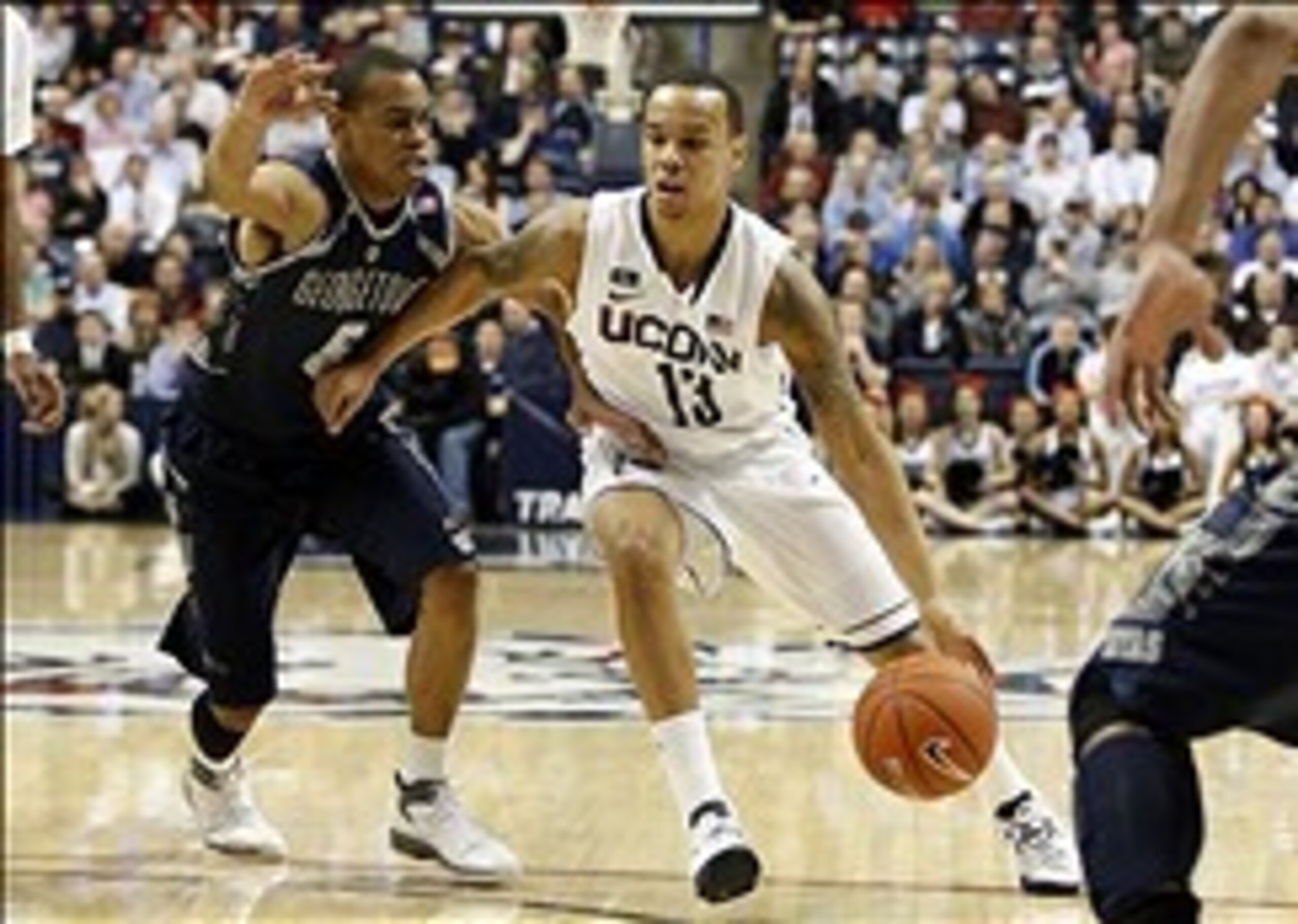 Feb 27, 2013; Storrs, CT, USA; Connecticut Huskies guard Shabazz Napier (13) drives the ball against Georgetown Hoyas guard Markel Starks (5) during the first half at Gampel Pavilion. Mandatory Credit: David Butler II-USA TODAY Sports