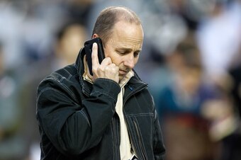 DETROIT, MI - OCTOBER 17:  New York Yankees general manager Brian Cashman talks on the phone on the field during batting practice against the Detroit Tigers during game four of the American League Championship Series at Comerica Park on October 17, 2012 i