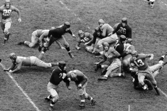 Kink Richards (13), New York Giants back, cuts over end for a 25-yard gain against the Cleveland Rams in the 2nd quarter of a National Football League game on Nov. 13, 1938 at the Polo Grounds in New York. Ward Cuff (14) is taking out an opposing backer-up. Others identified are Giants Tuffy Leemans (4); Gildea (17) and Cope (36); Rams are Ted Livingston (31), and Benton (26). Giants won 28-0.