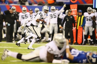 EAST RUTHERFORD, NJ - NOVEMBER 10:  Tracy Porter #23 of the Oakland Raiders runs for a touchdown after intercepting  Eli Manning #10 of the New York Giants who is in the foreground in the second quarter during their game at MetLife Stadium on November 10,