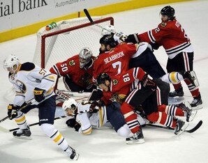 Several Blackhawks get in a scrum around the goal crease.
