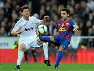 MADRID, SPAIN - JANUARY 18:  Xavi Hernandez (R) of Barcelona controls the ball beside Xabi Alonso of Real Madridduring the Copa del Rey Quarter Finals match between Real Madrid and Barcelona at Estadio Santiago Bernabeu on January 18, 2012 in Madrid, Spai