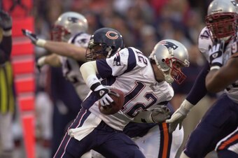 CHAMPAIGN, IL - NOVEMBER 10: Quarterback Tom Brady #12 of the New England Patriots tries to avoid the rush of Chicago Bears defenders on November 10, 2002 at Memorial Stadium at the University of Illinois in Champaign, Illinois.  (Photo by Jonathan Daniel