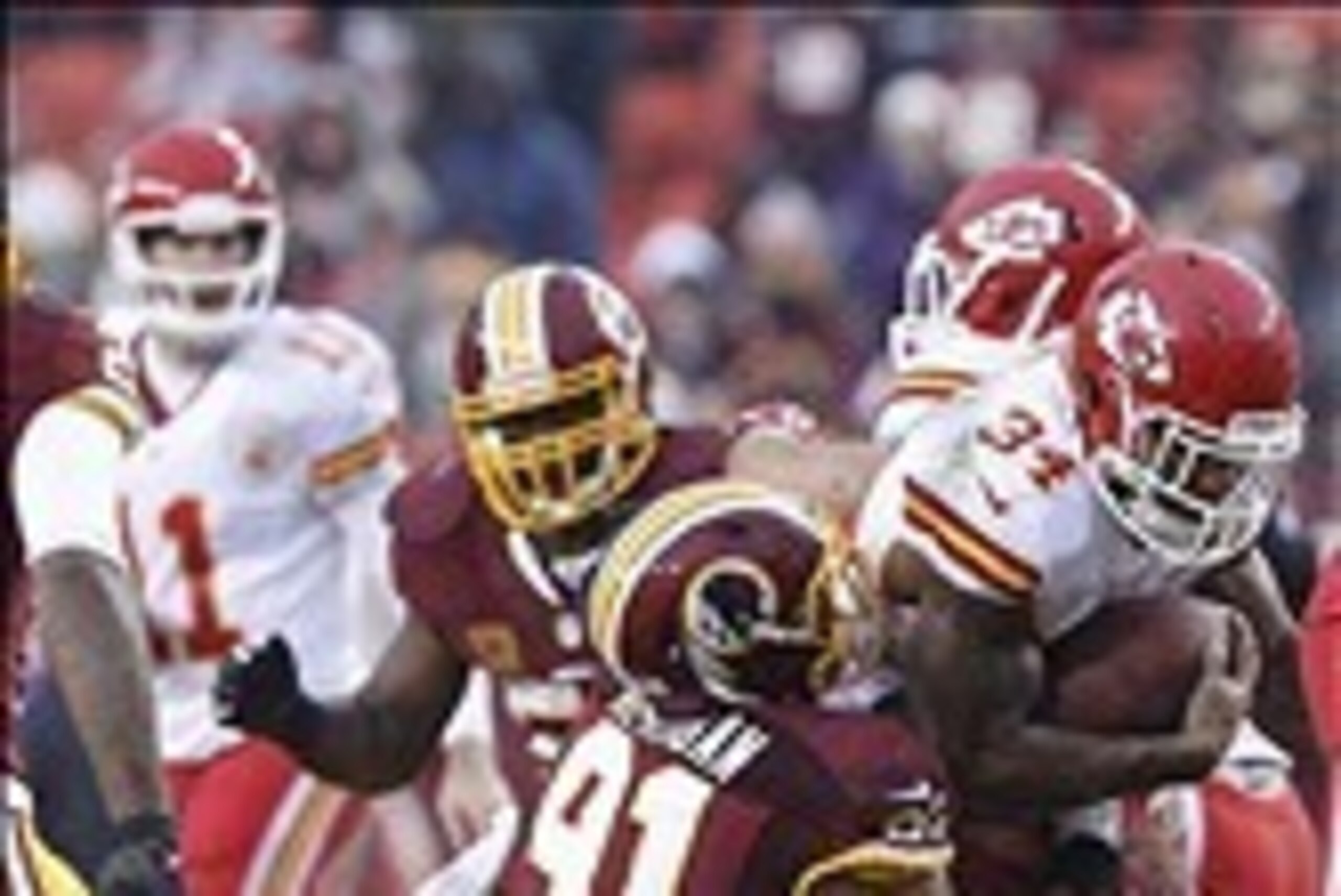 Dec 8, 2013; Landover, MD, USA; Kansas City Chiefs running back Knile Davis (34) carries the ball as Washington Redskins outside linebacker Ryan Kerrigan (91) dives for the tackle in the third quarter at FedEx Field. The Chiefs won 45-10. Mandatory Credit