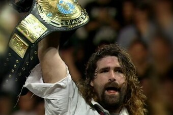 Mick Foley hoists the WWE Championship.