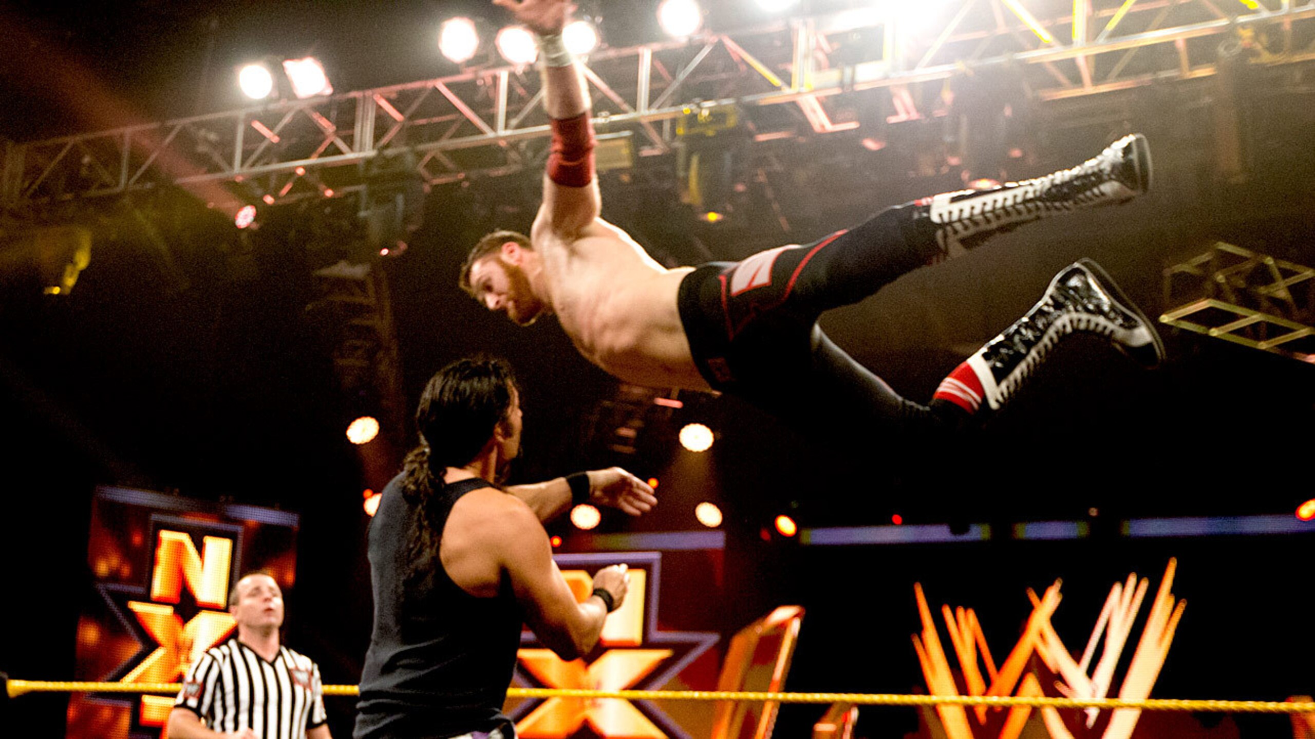 Sami Zayn soars at Leo Kruger.