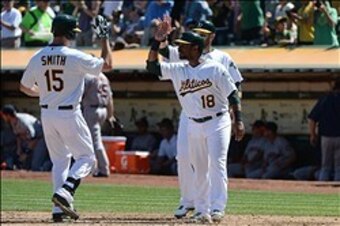 Seth Smith touches home plate during an A's home game.