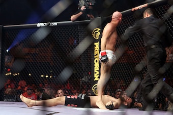 Burkman stands over an unconscious Fitch.