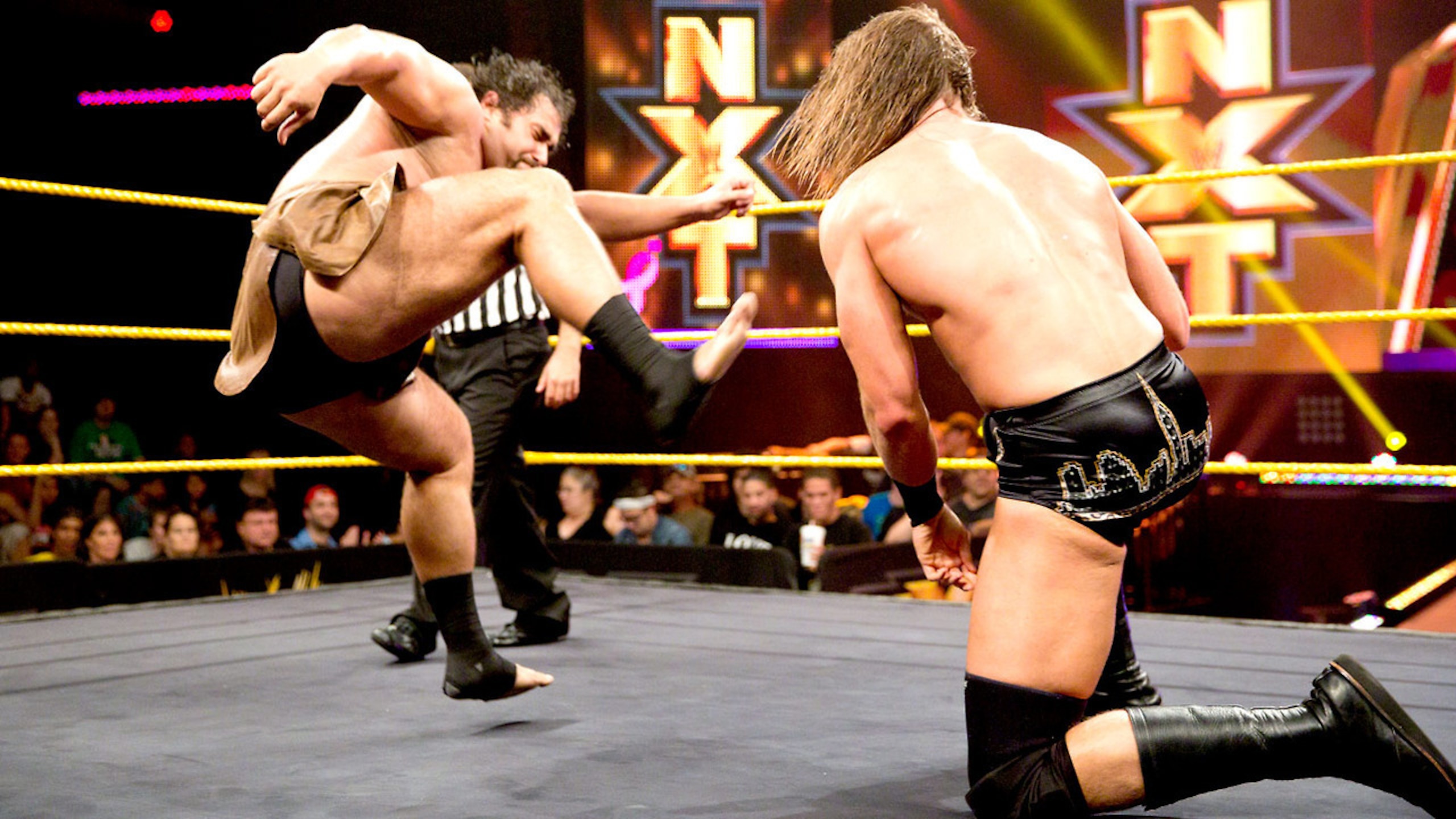 Alexander Rusev attacks Kassius Ohno.