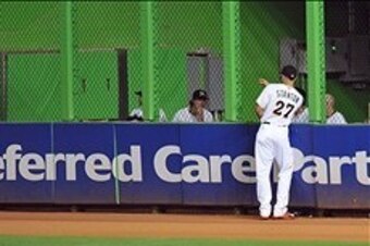 Giancarlo Stanton (27) is talking to members of the Miami Marlins bullpen. The Marlins are looking to add a veteran reliever to join in on the conversations, among other things.