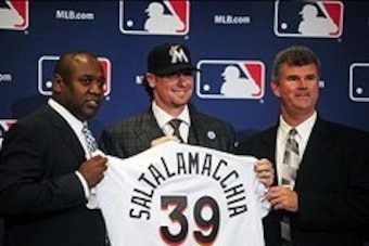 Dec 9, 2013; Orlando, FL, USA; Catcher Jarrod Saltalamacchia (center) is introduced by Miami Marlins director of baseball operations Michael Hill (left) and general manager Dan Jennings (right) during the MLB Winter Meetings at the Walt Disney World Swan 