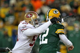 GREEN BAY, WI - JANUARY 05: Ahmad Brooks #55 of the San Fransico 49ers hits Aaron Rodgers #12 of the Green Bay Packers during an NFC Wild Card Playoff game at Lambeau Field on January 5, 2014 in Green Bay, Wisconsin. The 49ers defeated the Packers 23-20. 