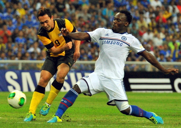 KUALA LUMPUR, MALAYSIA - JULY 21:  Michael Essien of Chelsea tackles Norsharul of Malaysia during the match between Chelsea and Malaysia XI on July 21, 2013 at the Shah Alam Stadium in Shah Alam, Kuala Lumpur, Malaysia.  (Photo by Stanley Chou/Getty Image