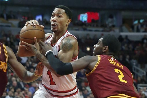 Chicago Bulls point guard Derrick Rose (1) drives past Cleveland Cavaliers point guard Kyrie Irving (2) during the second half of an NBA basketball game Monday, Nov. 11, 2013, in Chicago. The Bulls won 96-81. (AP Photo/Charles Rex Arbogast)