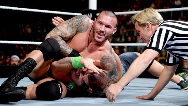 Randy Orton puts John Cena in a headlock.