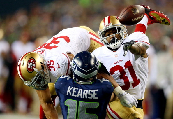 SEATTLE, WA - JANUARY 19:  Wide receiver Jermaine Kearse #15 of the Seattle Seahawks is hit by free safety Eric Reid #35 and strong safety Donte Whitner #31 of the San Francisco 49ers to break up the pass in the second half in the 2014 NFC Championship at
