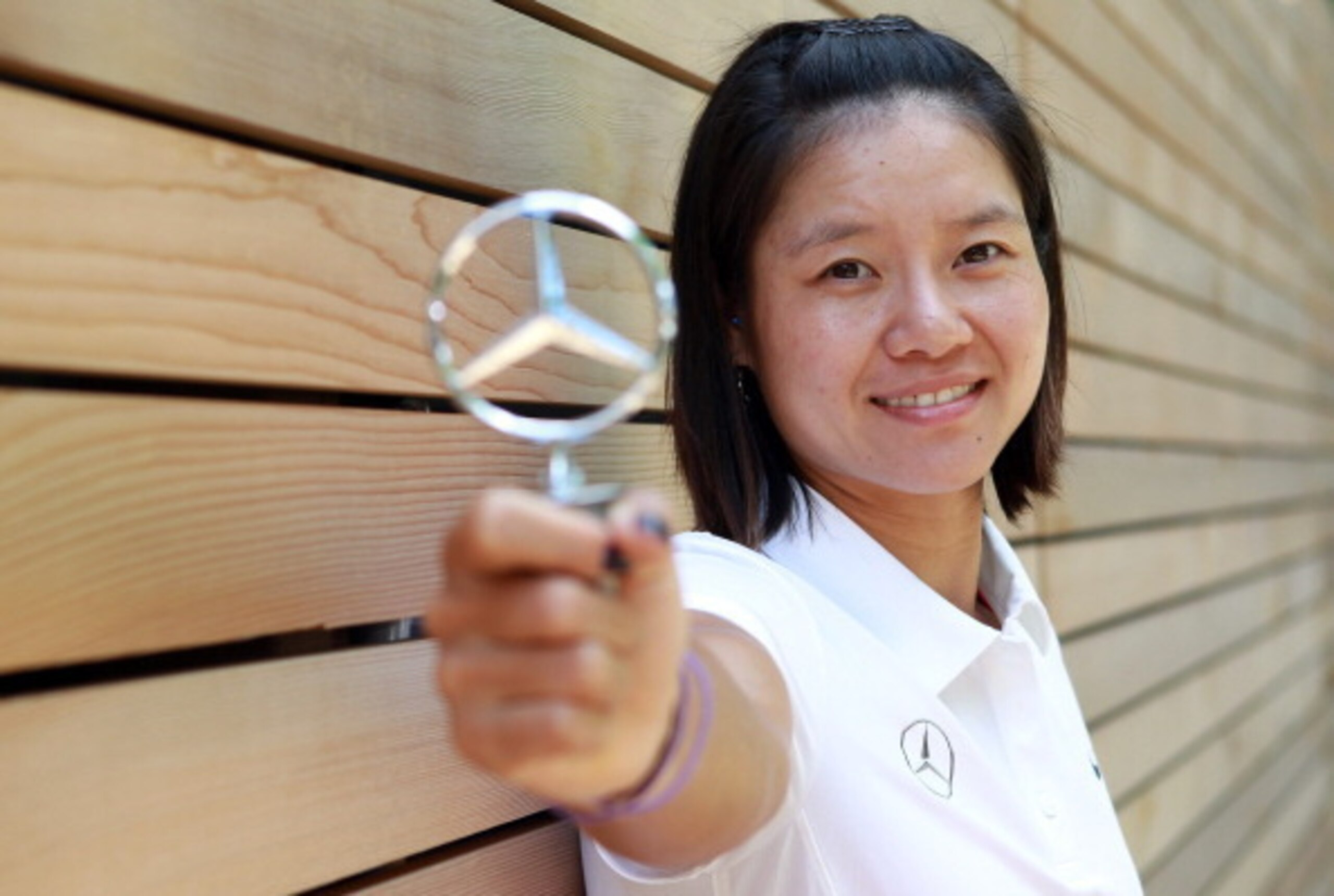 Li Na shows off Mercedes emblem. Li Na shows off Mercedes emblem.