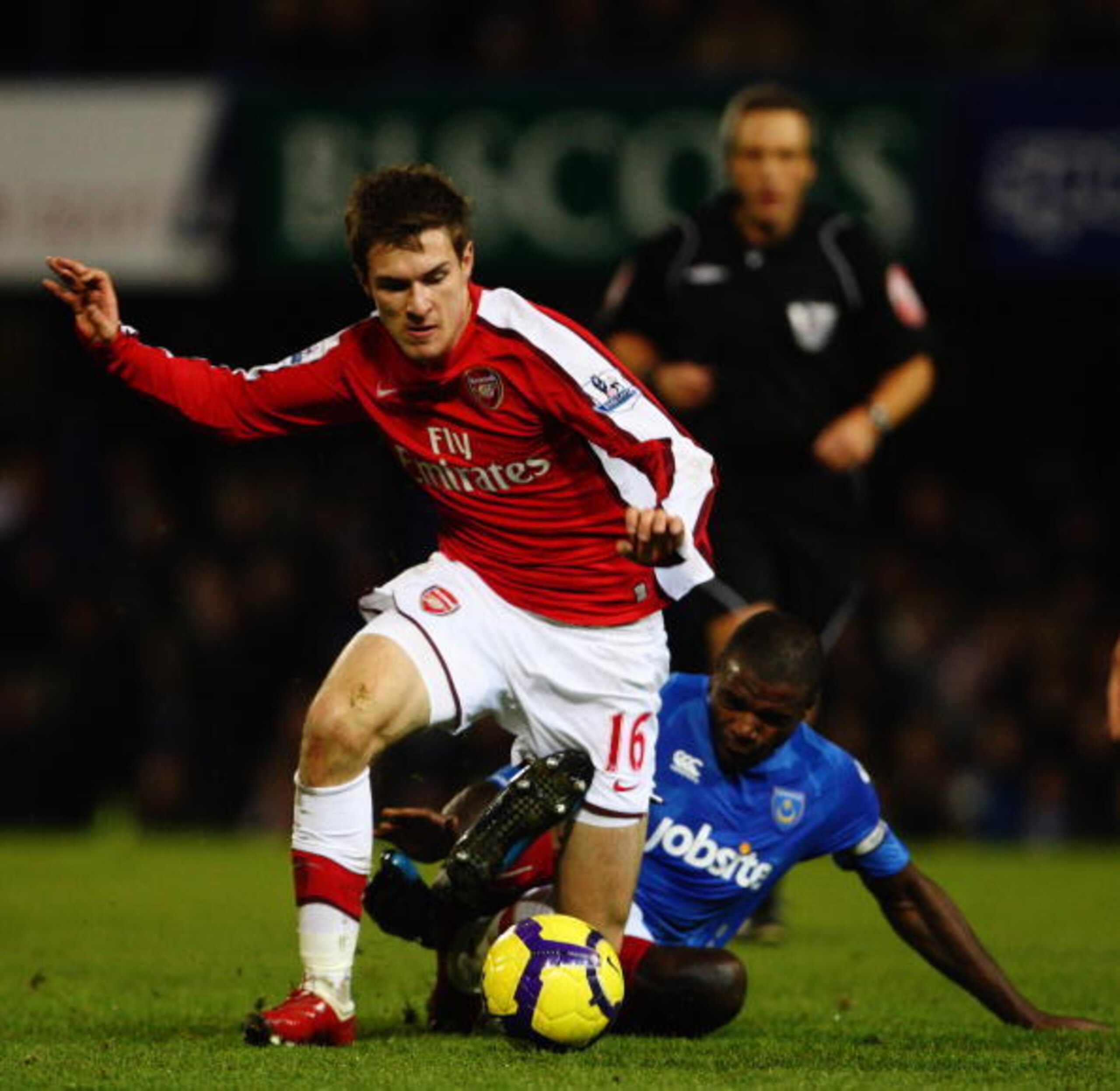 PORTSMOUTH, ENGLAND - DECEMBER 30:  Aaron Mokoena of Portsmouth challenges Aaron Ramsey of Arsenal during the Barclays Premier League match between Portsmouth and Arsenal at Fratton Park on December 30, 2009 in Portsmouth, England.  (Photo by Phil Cole/Ge