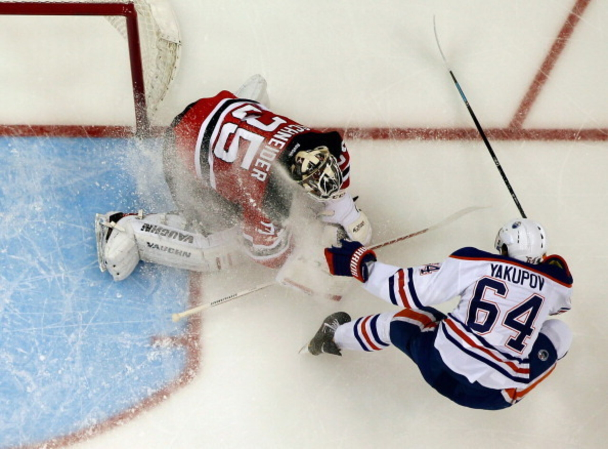 NEWARK, NJ - FEBRUARY 07: Nail Yakupov #64 of the Edmonton Oilers gives a snow shower to Cory Schneider #35 of the New Jersey Devils at the Prudential Center on February 7, 2014 in Newark, New Jersey. (Photo by Andy Marlin/NHLI via Getty Images)