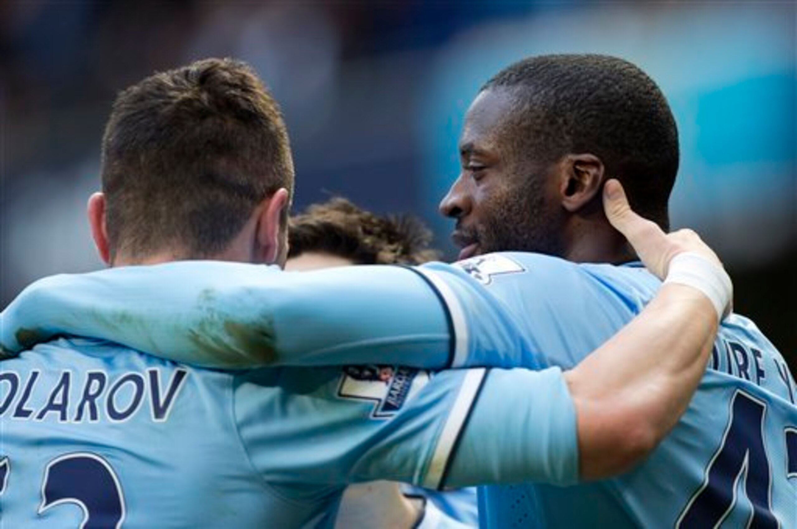 Manchester City's Yaya Toure, right, celebrates with teammates including Aleksander Kolarov, left, after scoring against Stoke during their English Premier League soccer match at the Etihad Stadium, Manchester, England, Saturday Feb. 22, 2014. (AP Photo/J