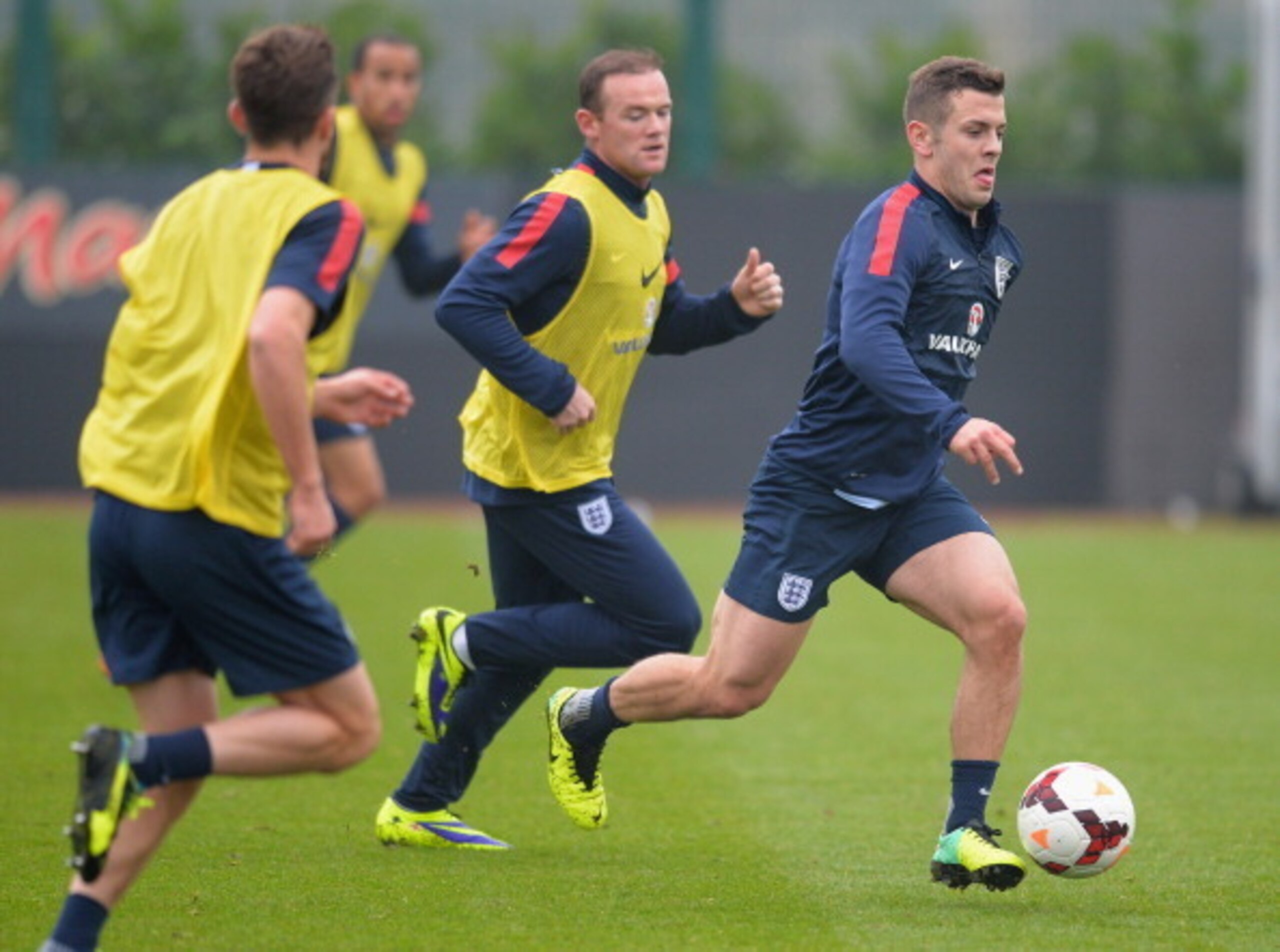 ST ALBANS, ENGLAND - NOVEMBER 18:  Jack Wilshire races away from Wayne Rooney during a England Training session at London Colney on November 18, 2013 in St Albans, England.  (Photo by Christopher Lee/Getty Images)