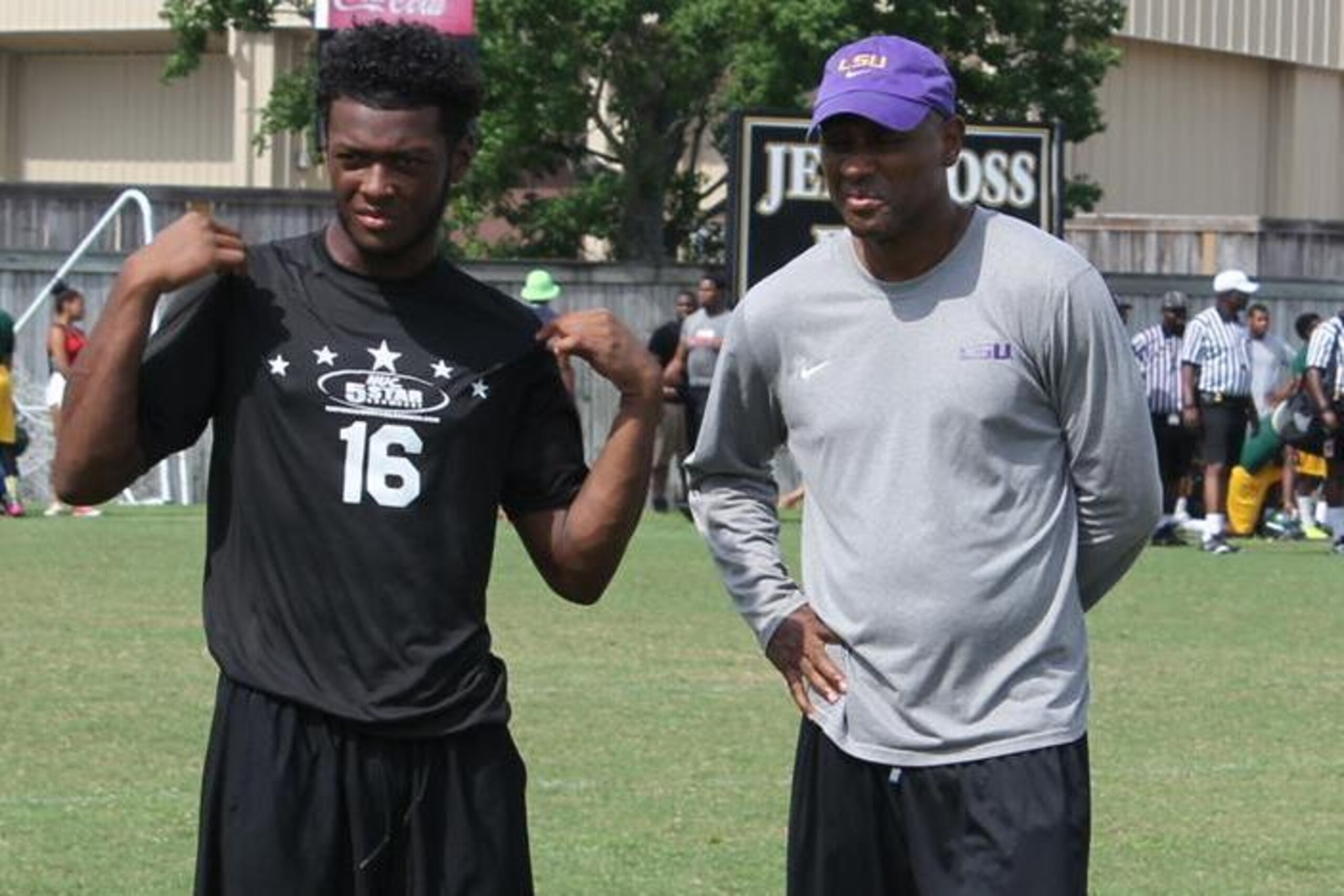 Xavier Lewis (left) stands with LSU defensive backs coach Corey Raymond (right).