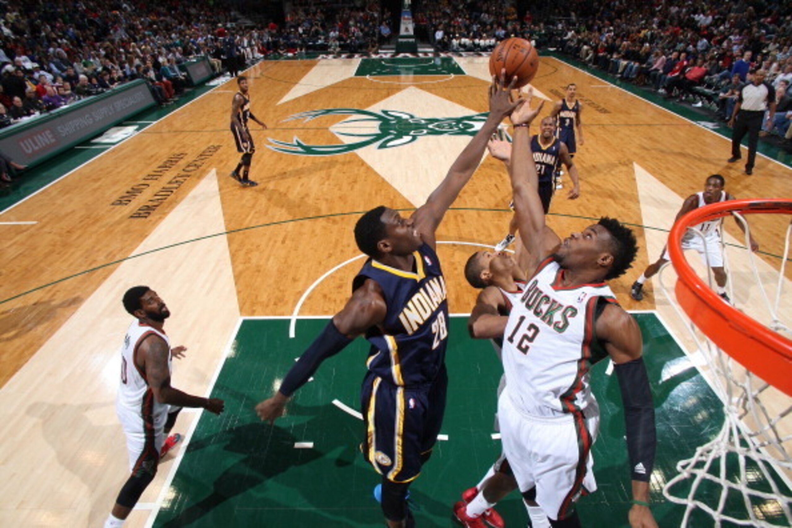 The Pacers' Ian Mahinmi (28) taps the loose ball away from Milwaukee Bucks forward Jeff Adrien. The Pacers' Ian Mahinmi (28) taps the loose ball away from Milwaukee Bucks forward Jeff Adrien.