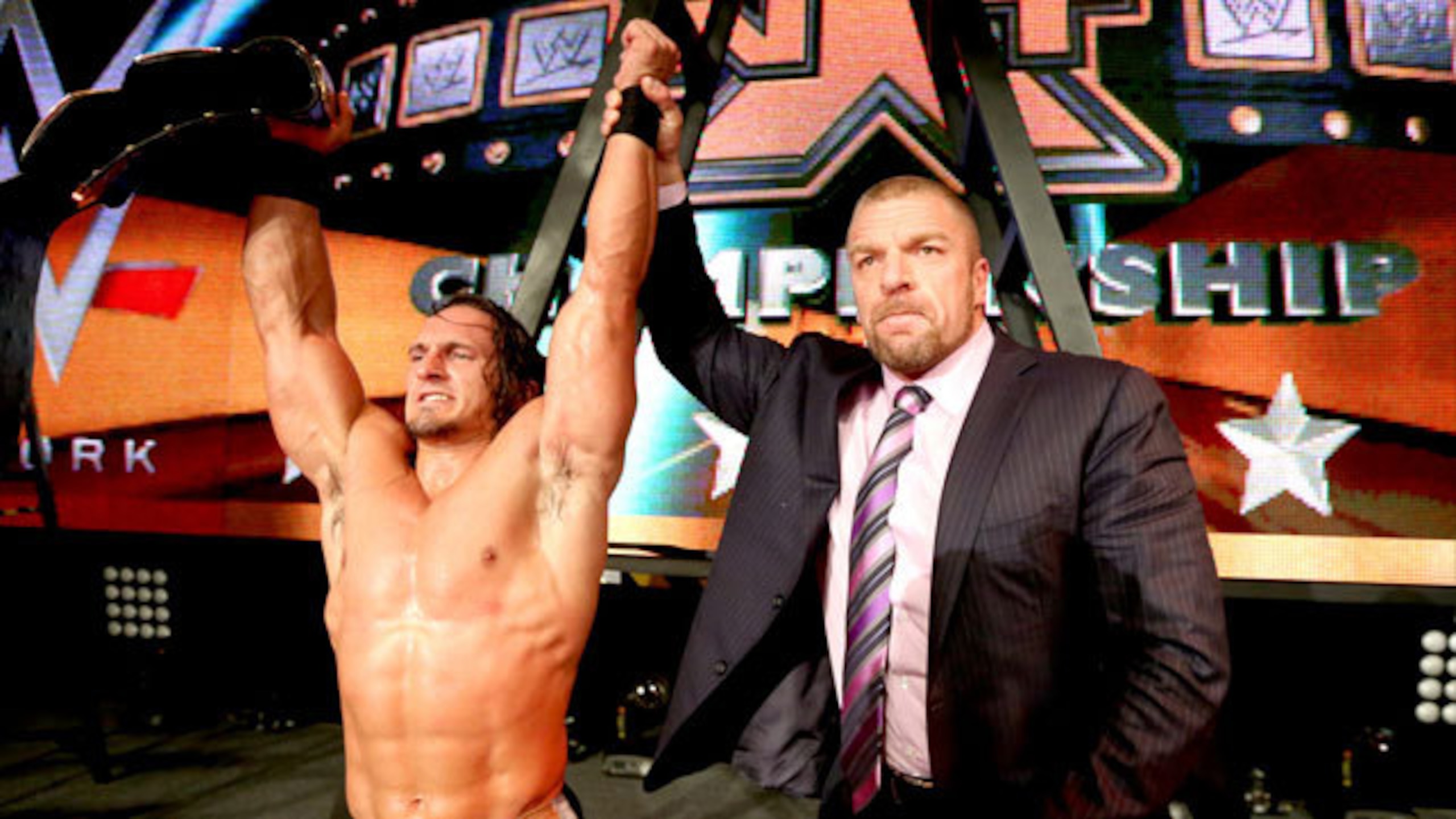 Triple H congratulates Adrian Neville on his title win.