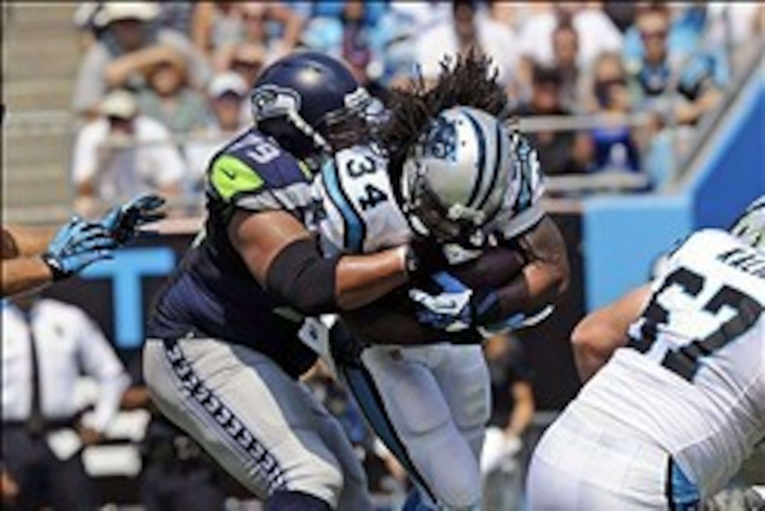 Sep 8, 2013; Charlotte, NC, USA; Carolina Panthers running back DeAngelo Williams (34) runs the ball as he is tackled by Seattle Seahawks defensive end Red Bryant (79) during the game at Bank of America Stadium. Mandatory Credit: Sam Sharpe-USA TODAY Spor