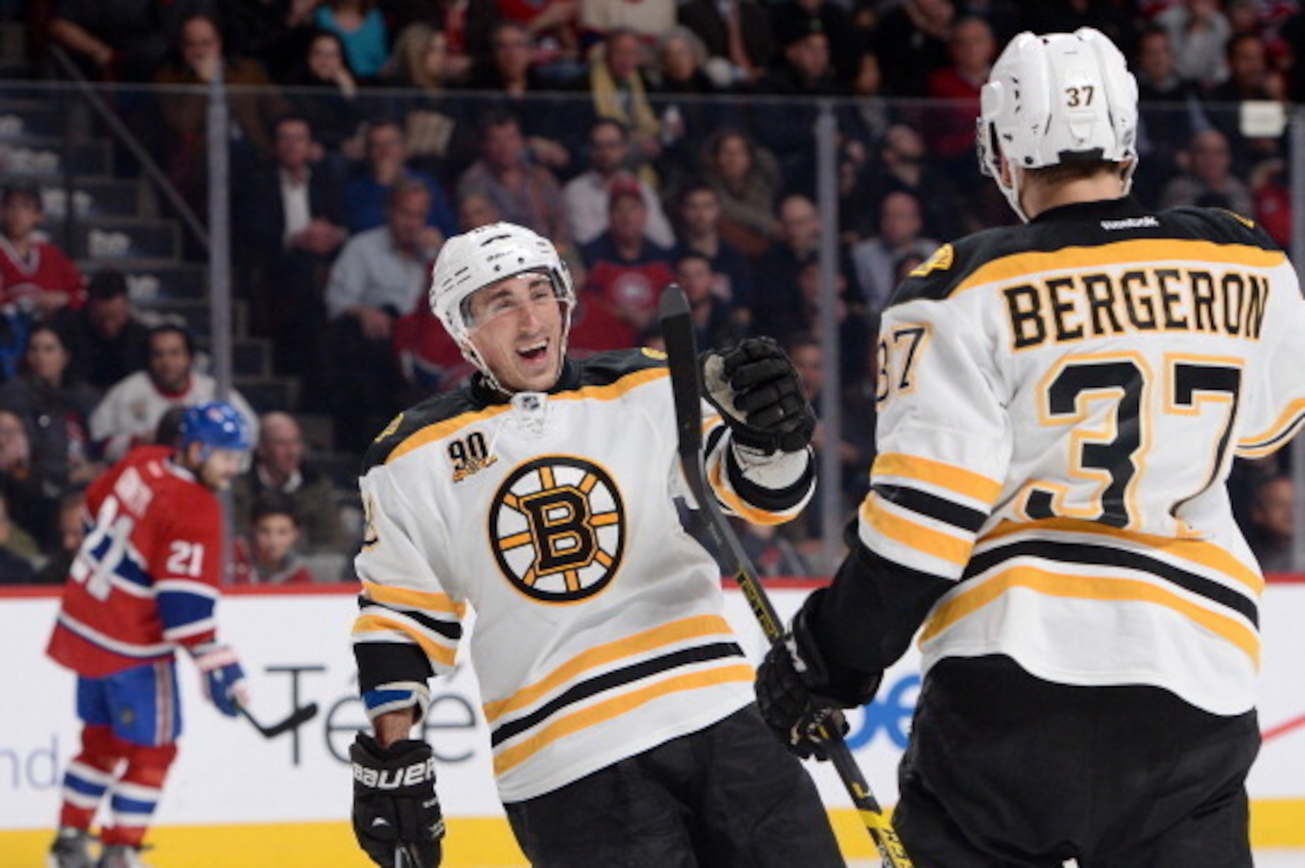 Boston Bruins forwards Brad Marchand and Patrice Bergeron celebrate a goal against the Montreal Canadiens.