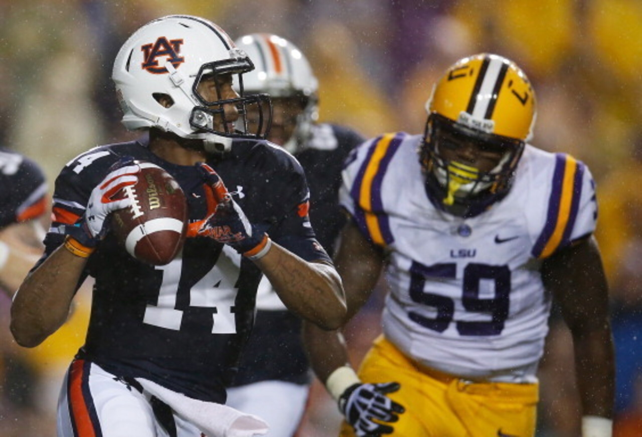 Auburn quarterback Nick Marshall looks to pass as LSU defensive end Jermauria Rasco chases him. Both will return this season, this time facing each other in Jordan-Hare.