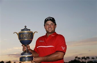 Patrick Reed holding the 2014 WGC-Cadillac trophy.