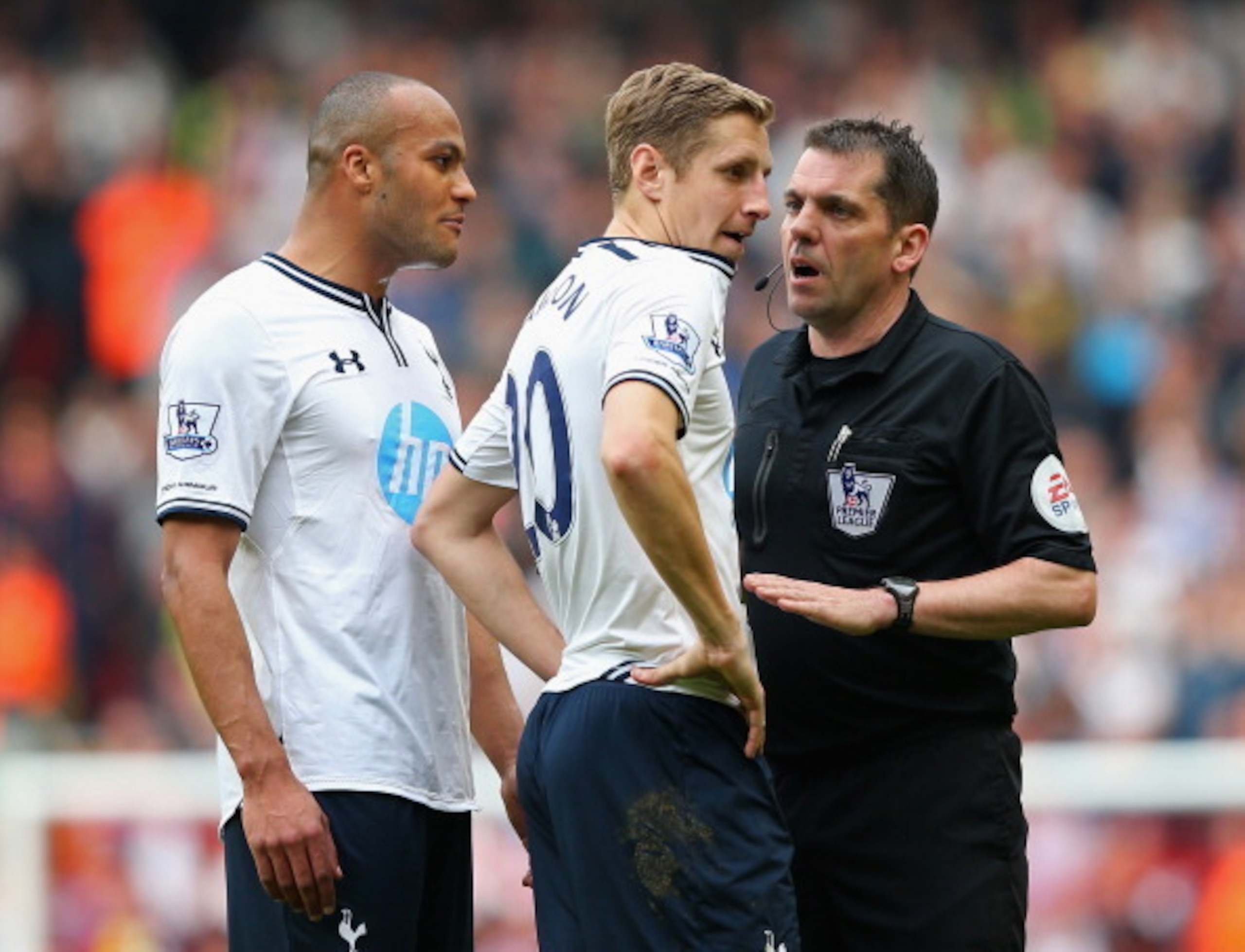 Spurs defenders Younes Kaboul and Michael Dawson talk to referee Phil Dowd at Anfield.