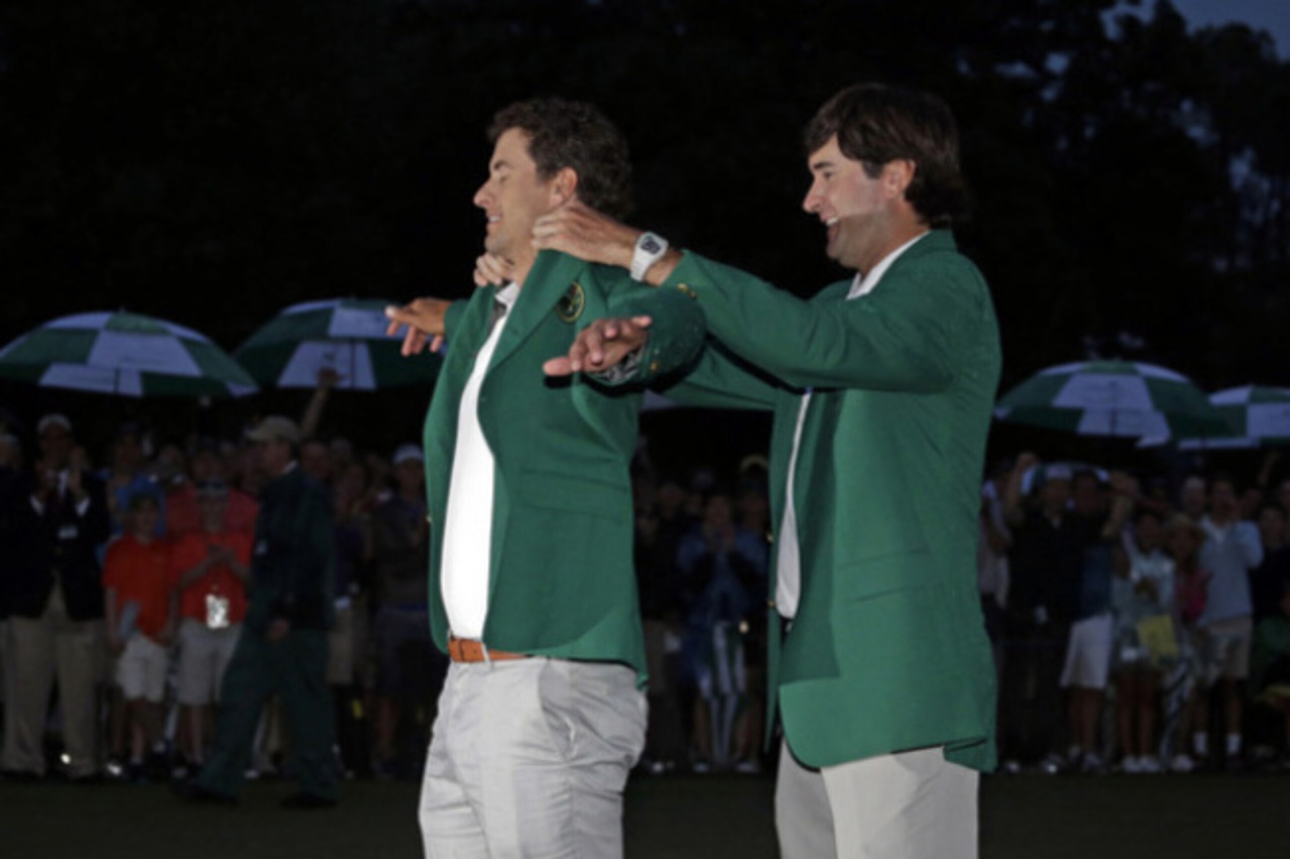 Bubba Watson putting the green jacket on 2013 champion Adam Scott.