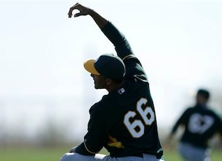 Michael Ynoa stretches while with the A's in spring training.