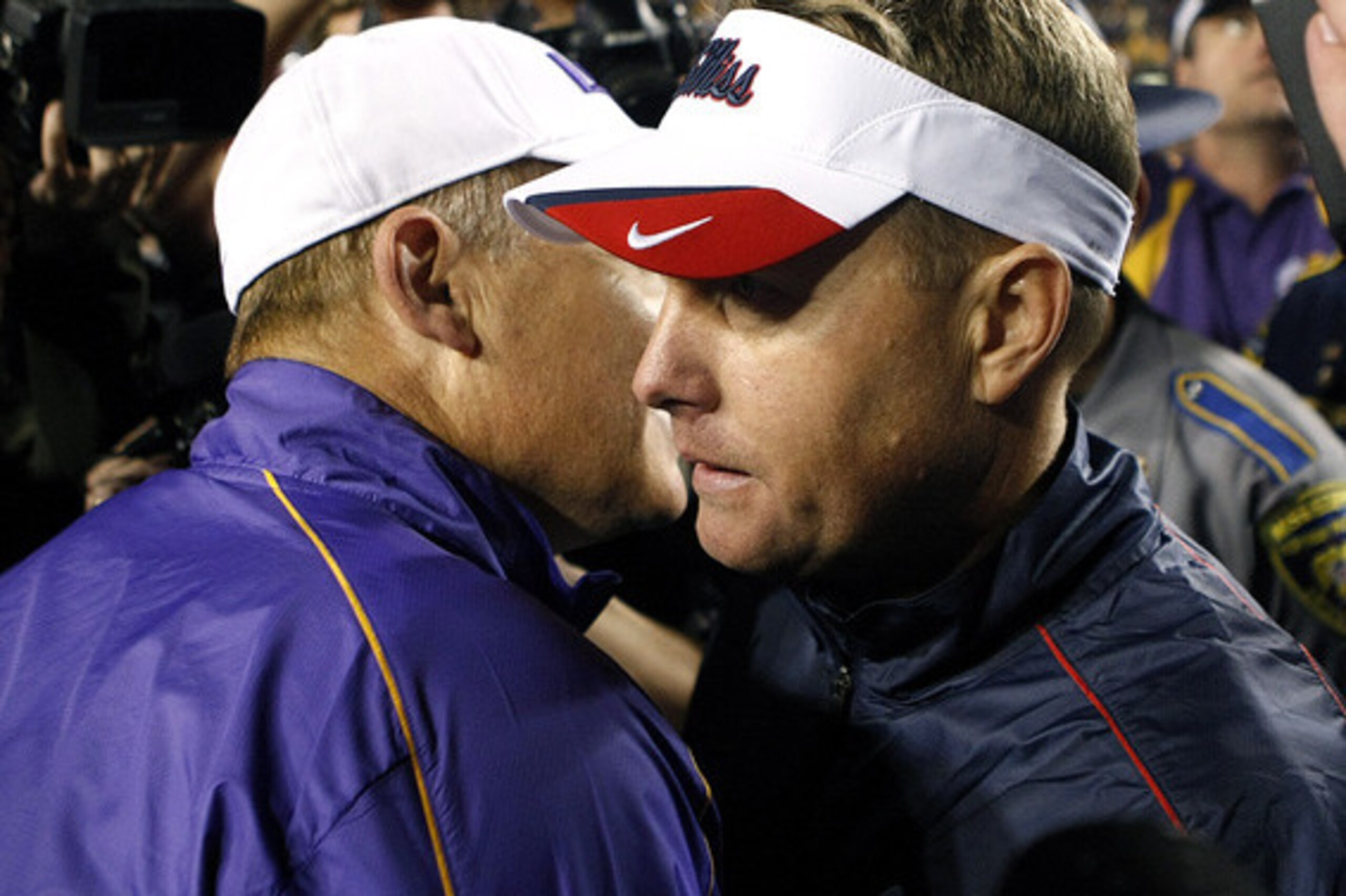 Les Miles (left) speaks with Ole Miss head coach Hugh Freeze (right).