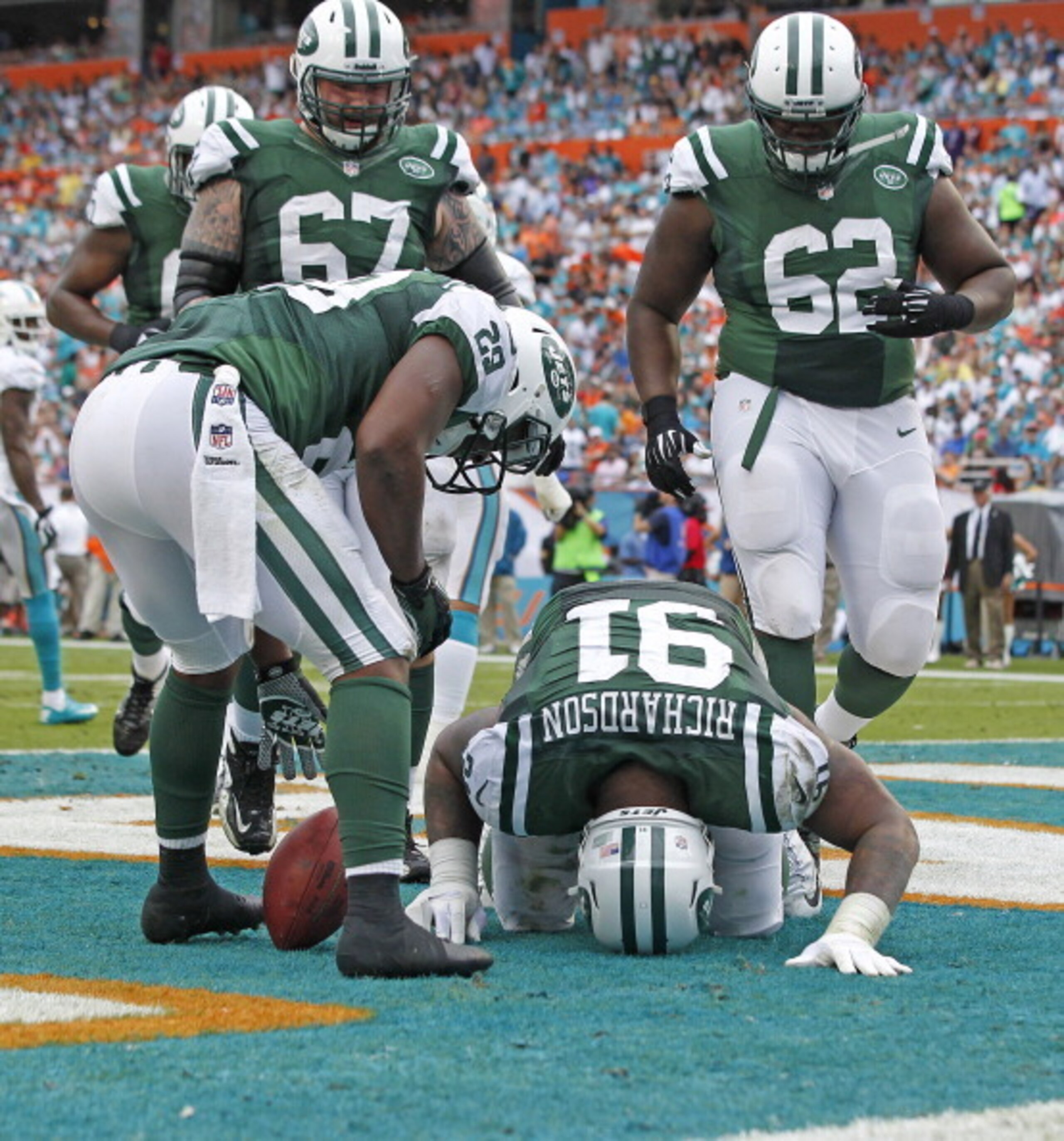 No. 62 Vladimir Ducasse and 2013 rookie Brian Winters surround "fullback" Sheldon Richardson at the Jets' season finale.