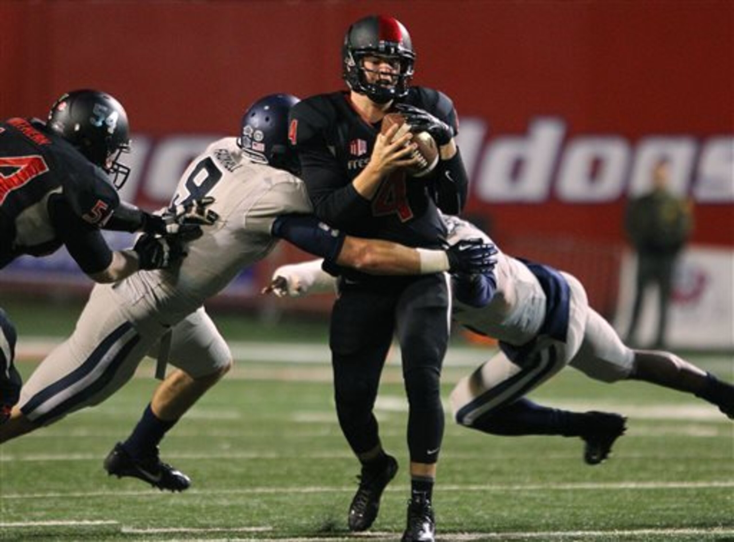 Fresno State's Derek Carr is chased by Utah State's Kyler Fackrell in the first half of an NCAA college football game in Fresno, Calif., Saturday, Dec. 7, 2013. (AP Photo/Gary Kazanjian)