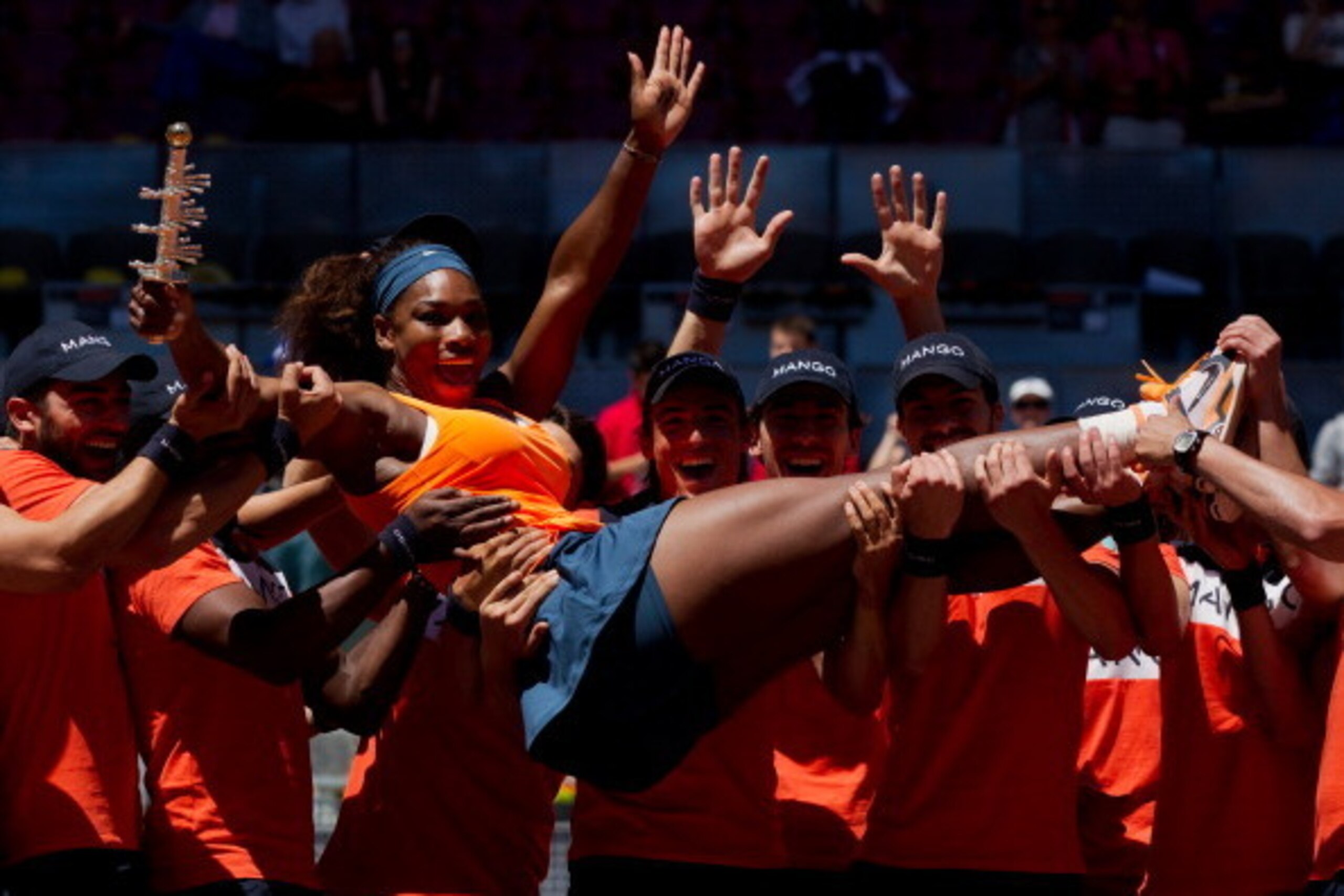 Serena Williams celebrates her 2013 win in Madrid with help from jubilant ball boys.