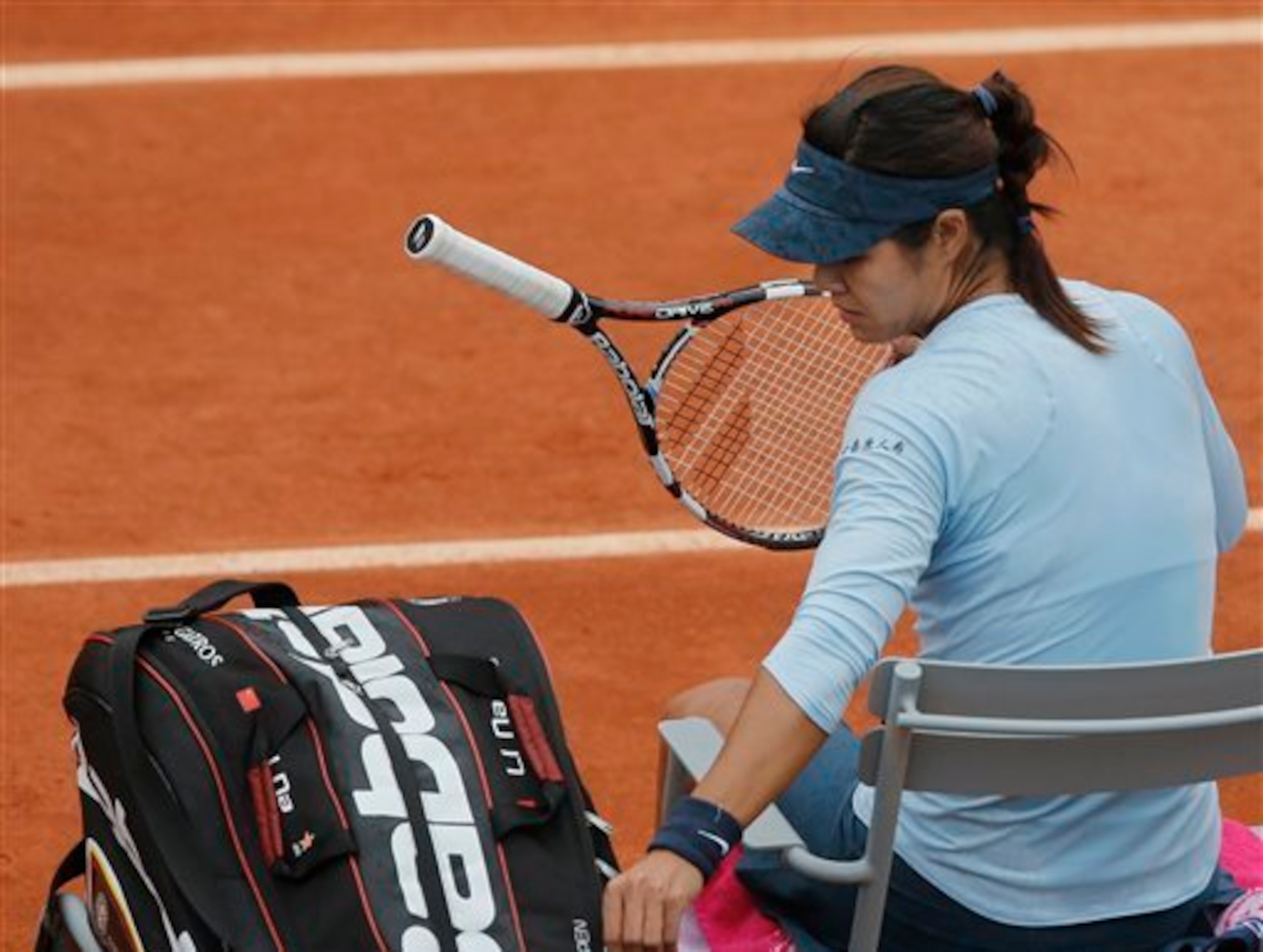 Li Na packs up after being upset by Bethanie Mattek-Sands at the 2013 French Open.