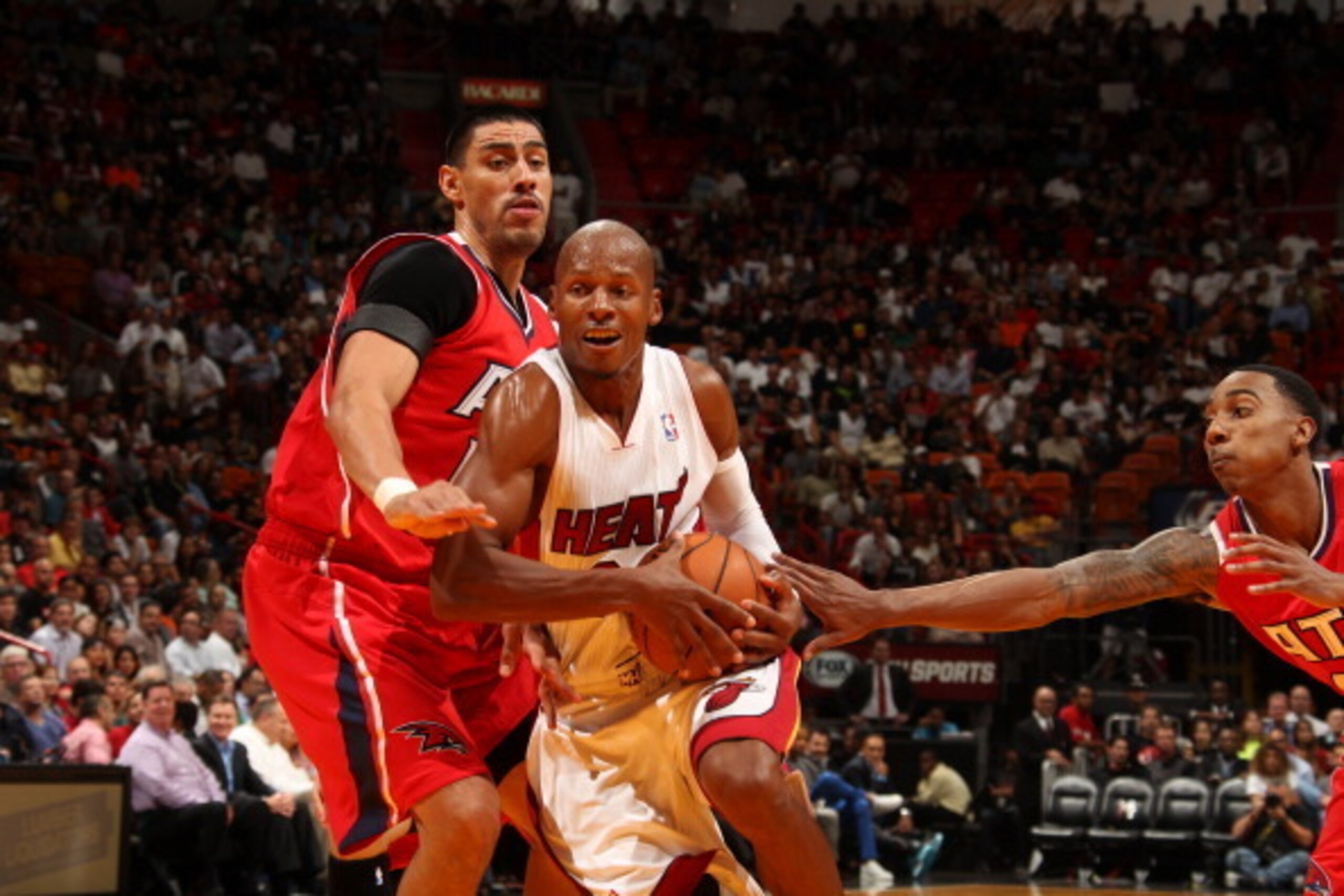 Gustavo Ayon defends against driving Miami Heat guard Ray Allen.