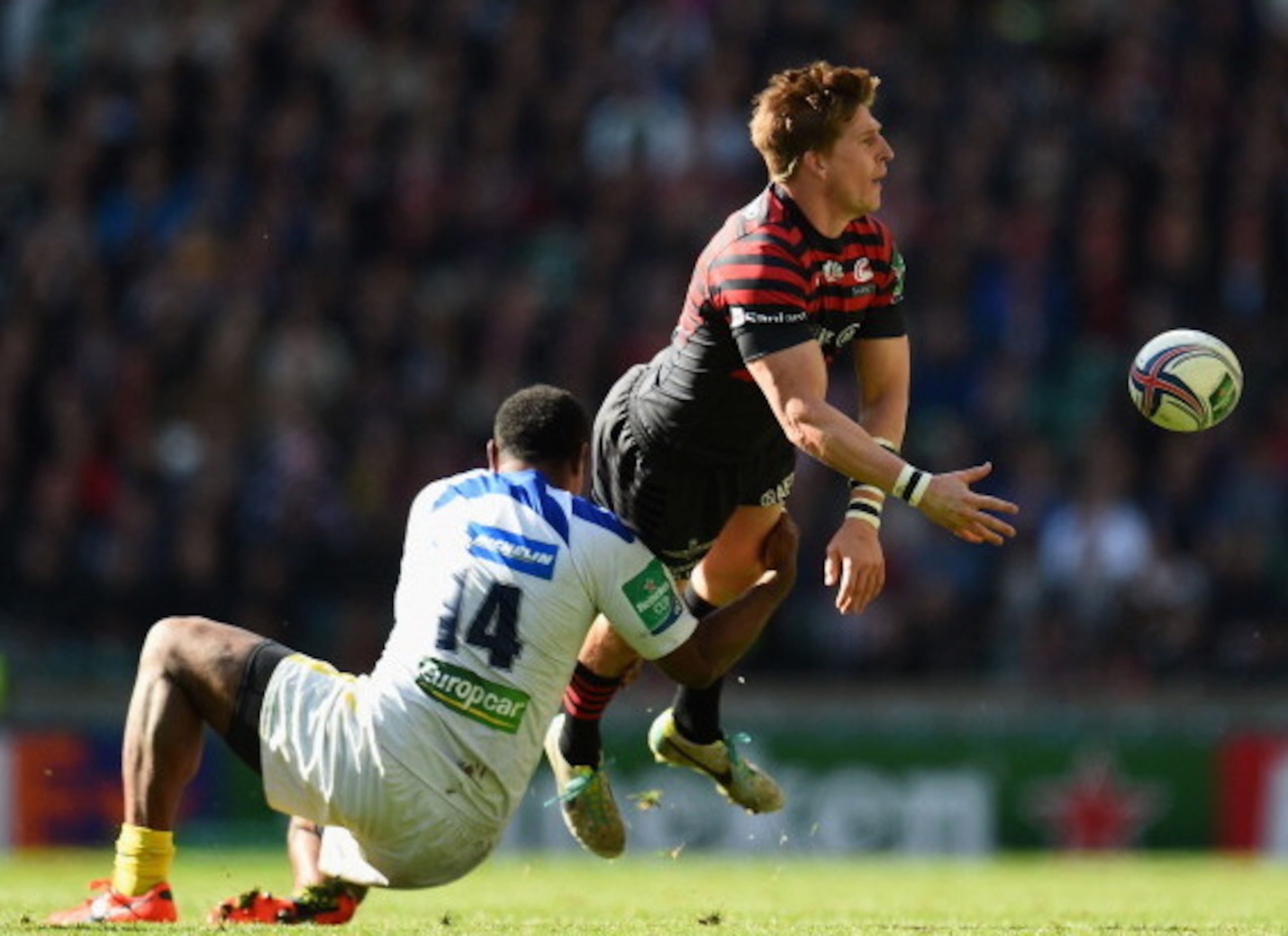 Saracens wing David Strettle offloads out of a tackle by Napolioni Nalaga