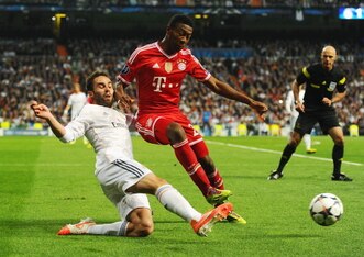 MADRID, SPAIN - APRIL 23: David Alaba of Bayern Muenchen is challenged by Daniel Carvajal of Real Madrid during the UEFA Champions League semi-final first leg match between Real Madrid and FC Bayern Muenchen at the Estadio Santiago Bernabeu on April 23, 2