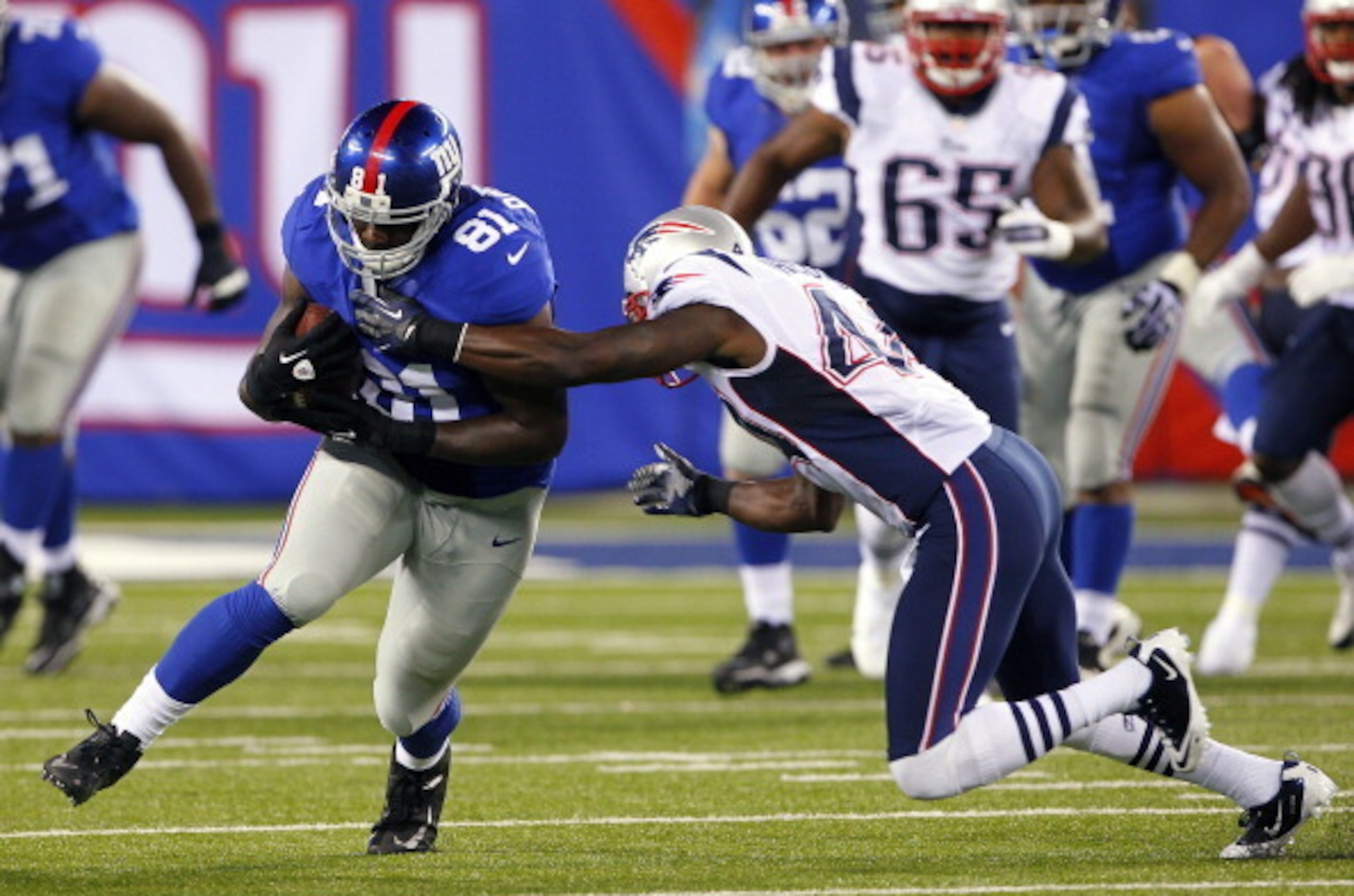EAST RUTHERFORD, NJ - AUGUST 29: Adrien Robinson #81 of the New York Giants attempts to elude James Ihedigbo #44 of the New England Patriots after making a catch during an NFL pre-season game at MetLife Stadium on August 29, 2012 in East Rutherford, New J