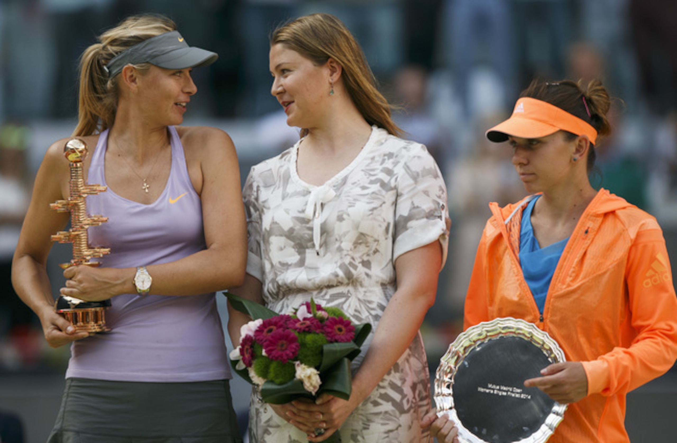 Maria Sharapova and former world No. 1 Dinara Safina chat as Simona Halep looks away during trophy ceremony in Madrid.