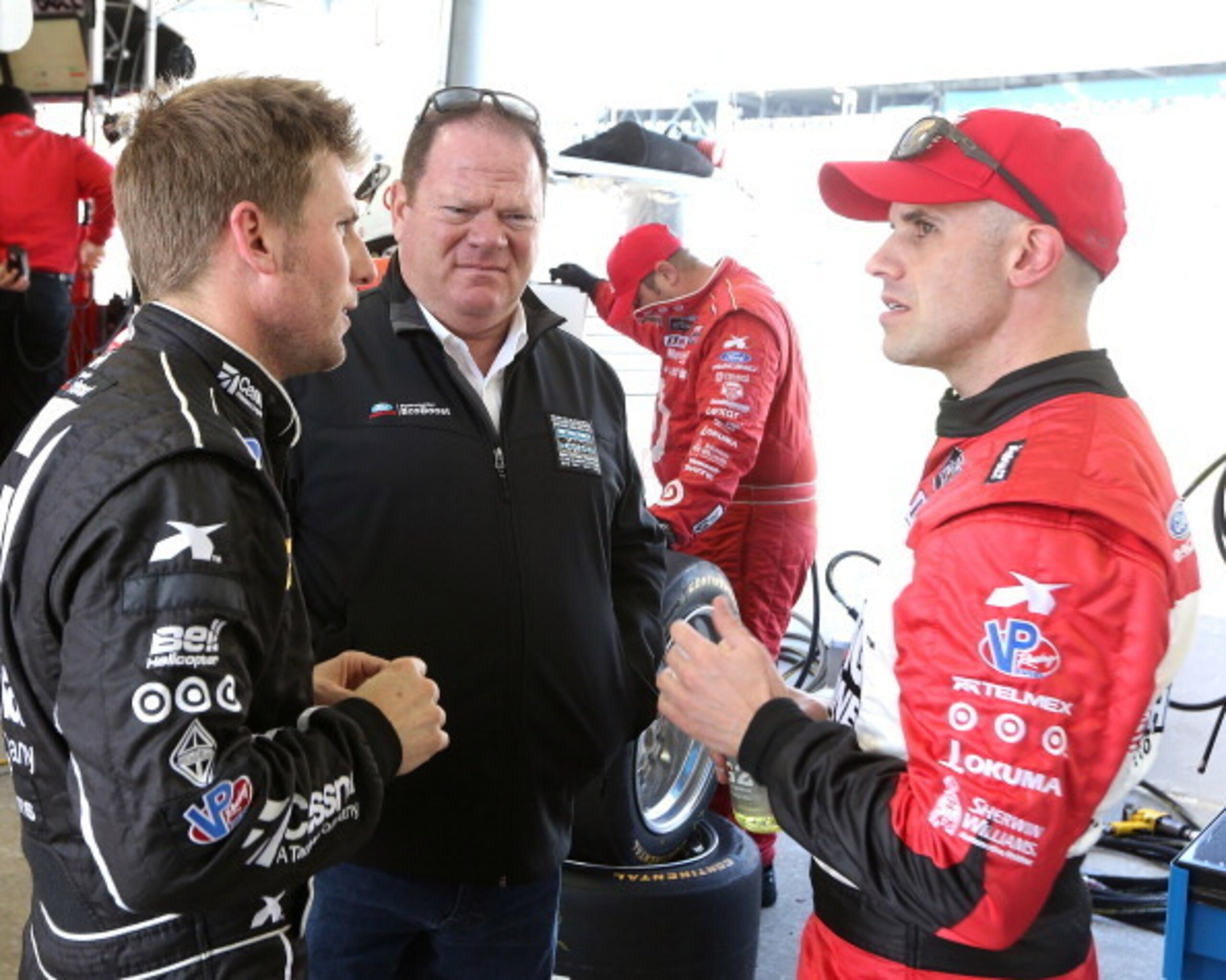 DAYTONA BEACH, FL - JANUARY 23:  Jamie McMurray and Mario Franchitti co-drivers of the #01 Chip Ganassi Racing  Telcel/Target Riley DP talk with team owner Chip Ganassi during practice for the Rolex 24 at Daytona International Speedway on January 23, 2014