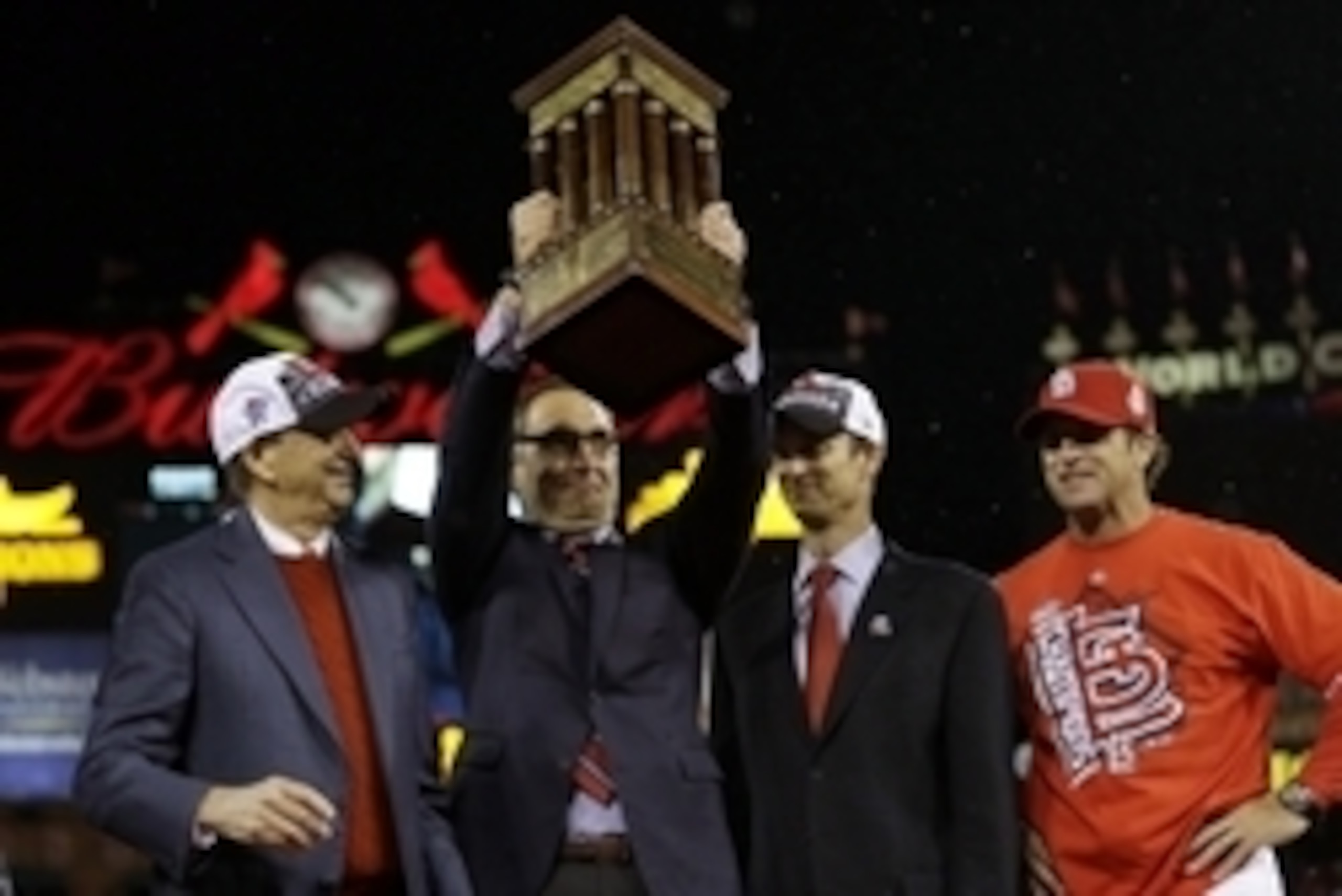 Cardinals' GM John Mozeliak hoists the Warren C. Giles trophy after winning the NL pennant in 2013.